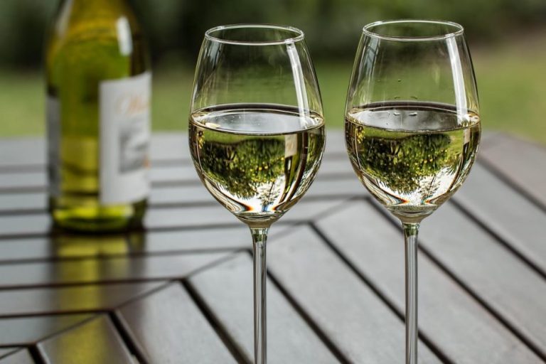Ons team Glas met witte wijn tegen achtergrond van wijngaarden, illustrerend hoe je de beste witte wijn kiest op basis van smaak en kw